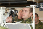 MCpl Paterson supervises his loader on the turret similitor as Sgt Morley and Cpl Elms watch.